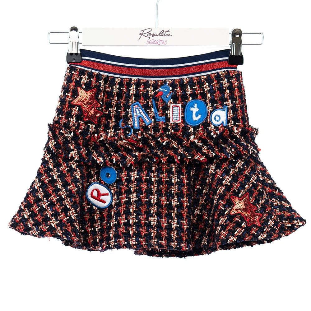 Wide skirt model of the Rosalita Senoritas girl's clothing line, in tartan patterned fabric, with...